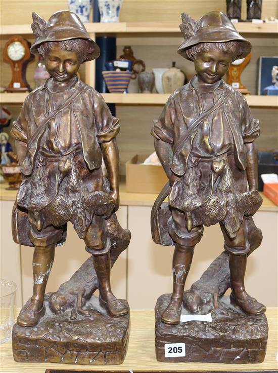 A pair of bronze figures of boys with rabbits, 52cm